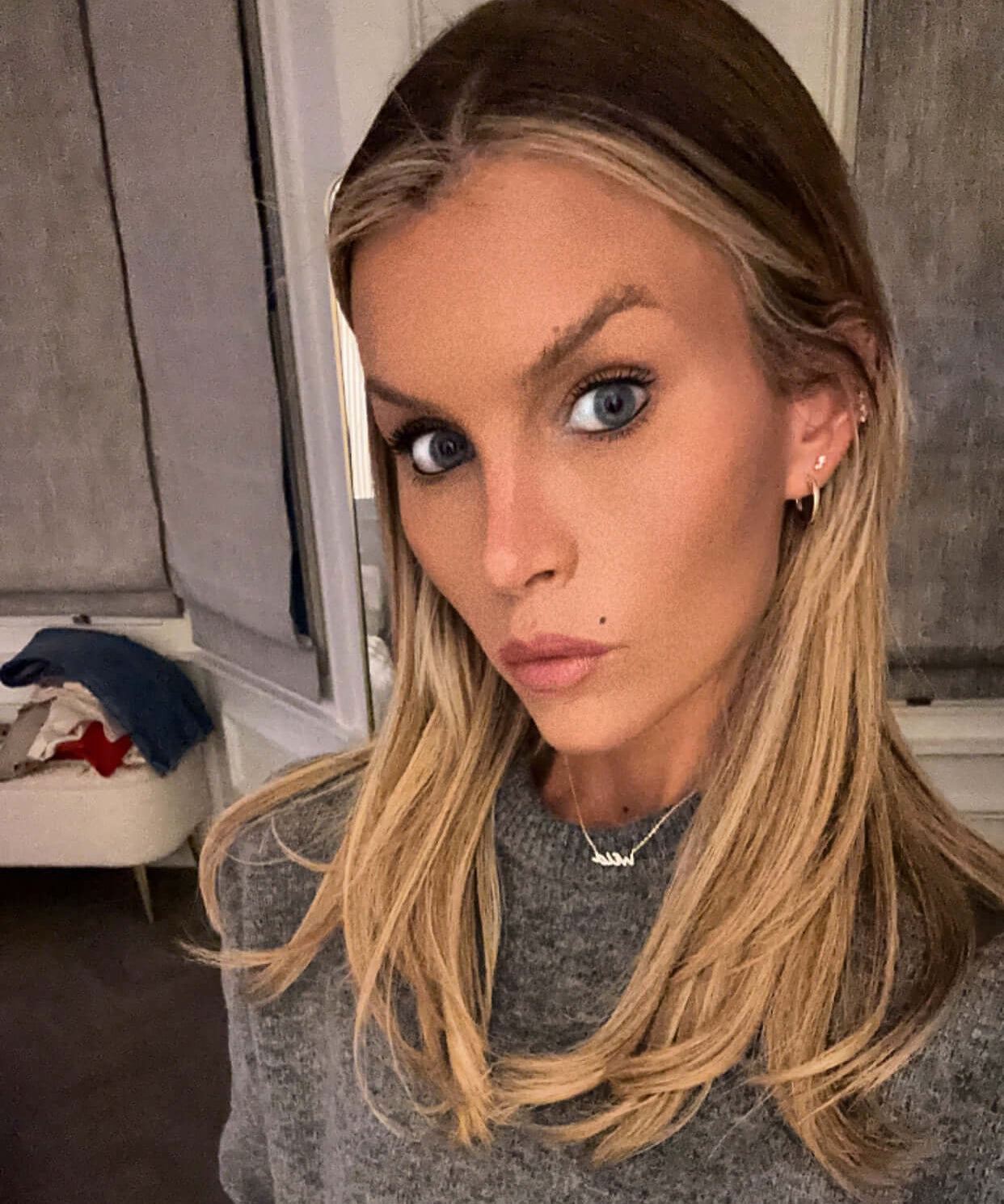 This Wild Soul Script Necklace worn by a model with long blonde hair and a cozy grey sweater.