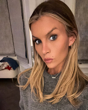 This Wild Soul Script Necklace worn by a model with long blonde hair and a cozy grey sweater.