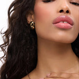 Born To Be Wild Leopard Earrings worn by a model with glowing skin, showcasing bold leopard print and statement jewelry.