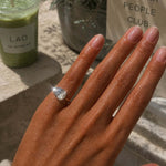 Showing the Kind Is Cool Pinky Ring worn on a hand, with a matcha drink in the background.