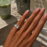 Showing the Kind Is Cool Pinky Ring worn on a hand, with a matcha drink in the background.