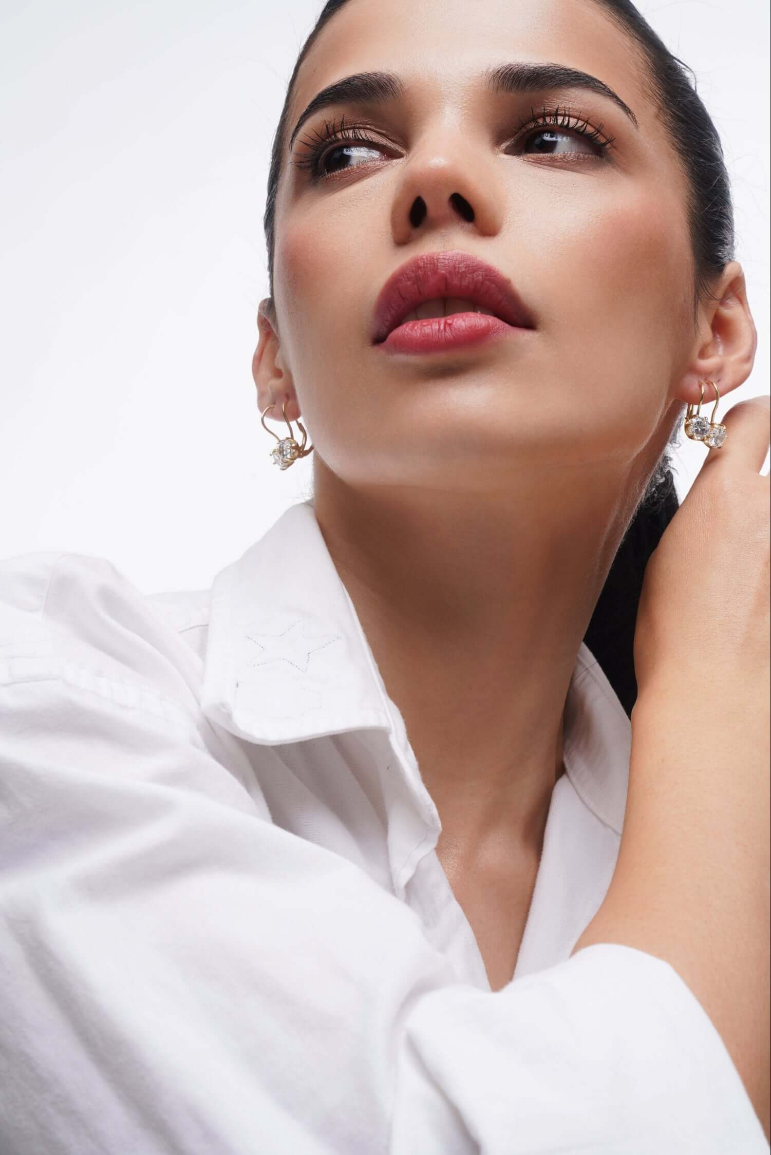Model wearing Good Times Earrings showcasing elegance and sparkle with a close-up of her face and jewelry.
