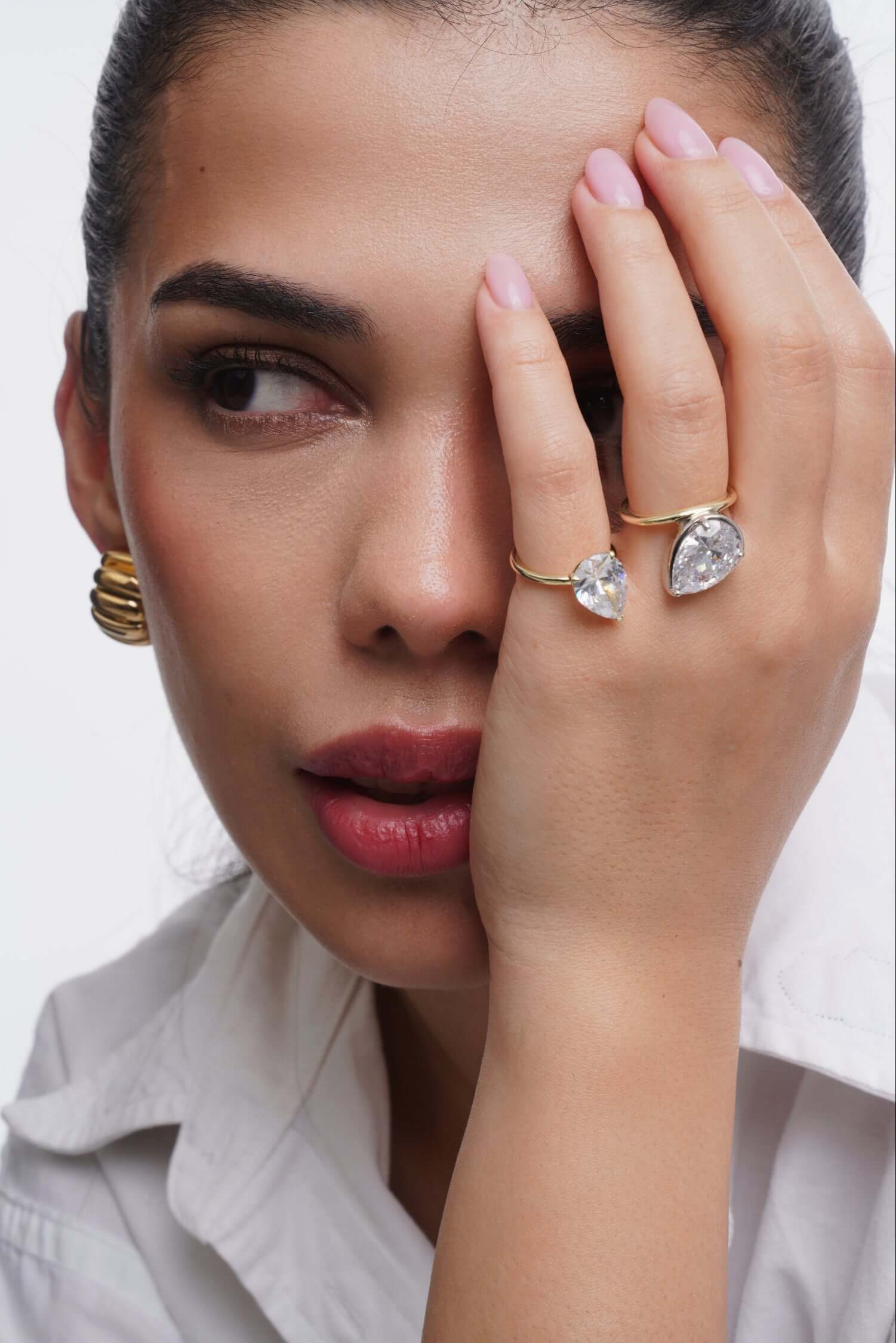 Close-up of a model showcasing the You Got This Pear Cut Halo Ring, featuring elegant pear cut design and gold accents.