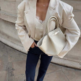 True Love Story Oval Solitaire Necklace worn with chic outfit featuring an oversized blazer and stylish handbag.