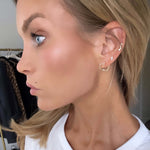 Model showcasing Follow Your Heart Gold Earrings, displaying elegant design and sophisticated style.