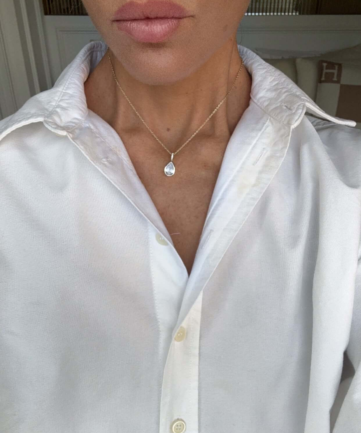 Model wearing the Time To Shine Pendant Necklace with a white shirt, showcasing its elegant design and pear drop pendant.