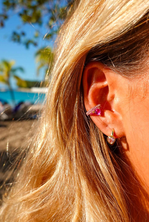 Love Actually Is All Around Pink Heart Huggie Earrings worn in an ear, showcasing pink heart detail and elegant design.