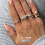 Hand adorned with new rings, showcasing The Rest Of The World Can Wait East-West Silver Ring.