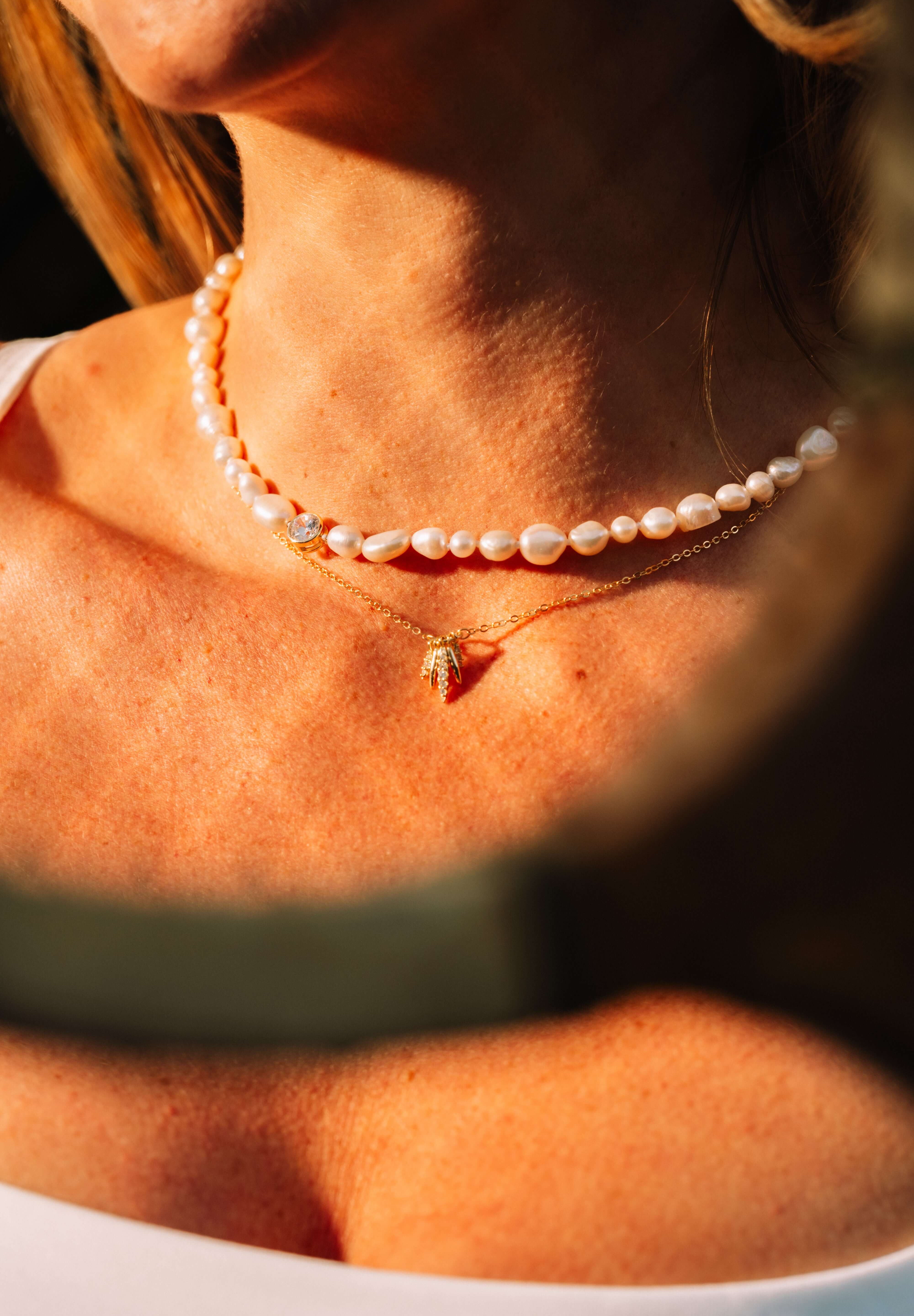 Pearl's A Singer Necklace featuring freshwater pearls on a silver chain with 14k gold plating and cubic zirconia.