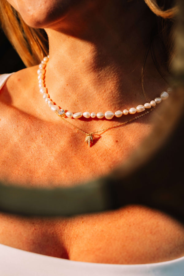 Pearl's A Singer Necklace featuring freshwater pearls on a silver chain with 14k gold plating and cubic zirconia.