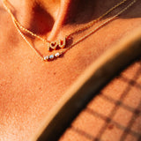 Starburst Opal Pendant Necklace elegantly layered with delicate gold chains, showcasing a minimalist style.