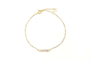 For The Lovers Gold L-O-V-E Bracelet featuring a delicate gold chain and a shimmering centerpiece.
