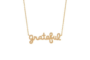 Grateful Script Gold Necklace with sparkling letters on a delicate chain showcased against a white background.