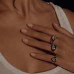 Excited About Everything Pinky Ring worn among other rings, showcasing its oversized pear-cut design and two-tone finish.