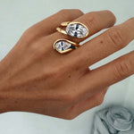 Close-up of a hand wearing the Can’t Compare Ring featuring two light-catching stones in a sculptural design.