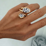 Close-up of a hand wearing the Can’t Compare Ring featuring two light-catching stones in a sculptural design.