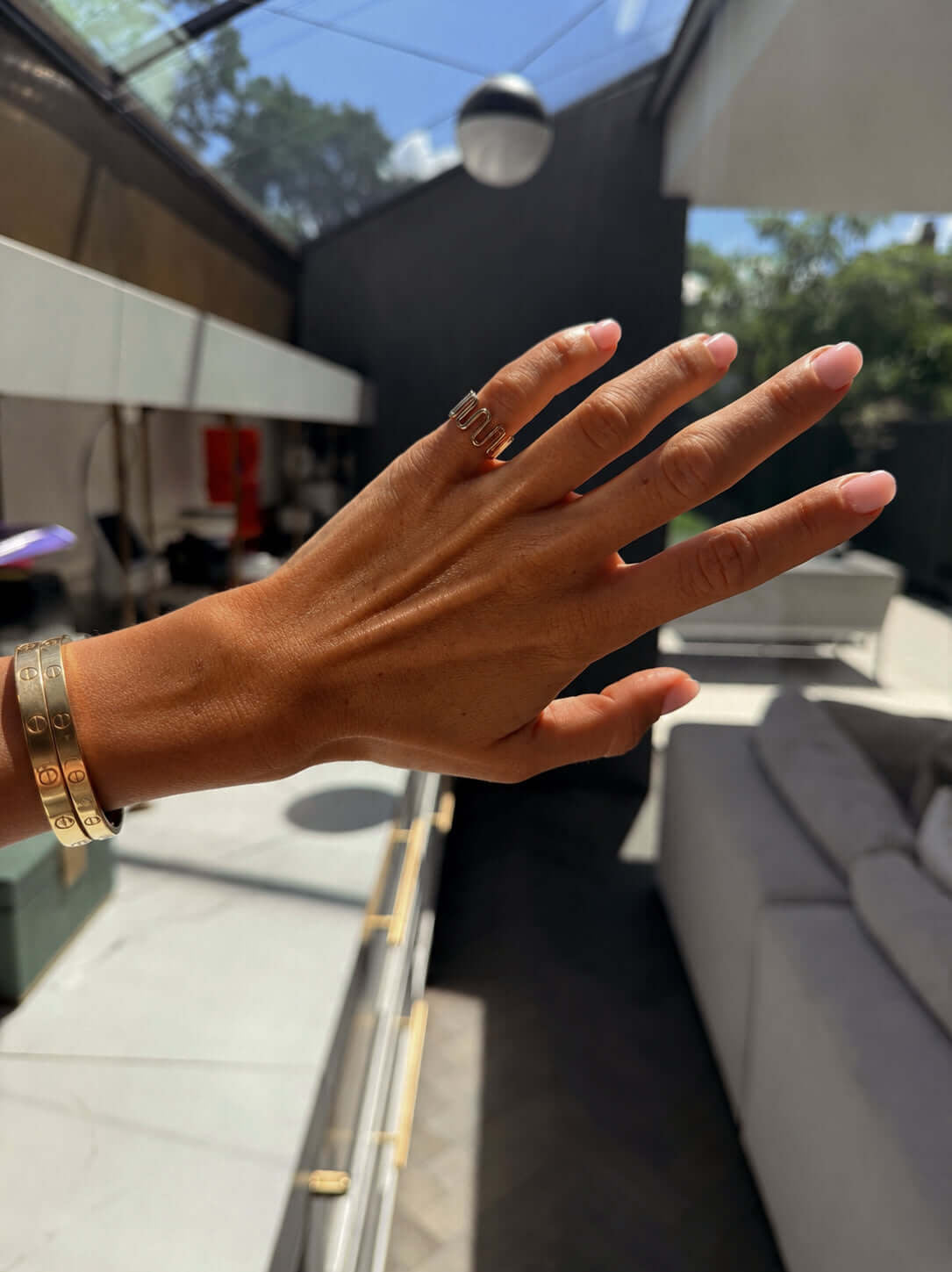 Hand wearing the Dilly Dally Pinky Ring, showcasing its elegant design and wider bracelets in a stylish setting.