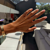 Hand wearing the Dilly Dally Pinky Ring, showcasing its elegant design and wider bracelets in a stylish setting.